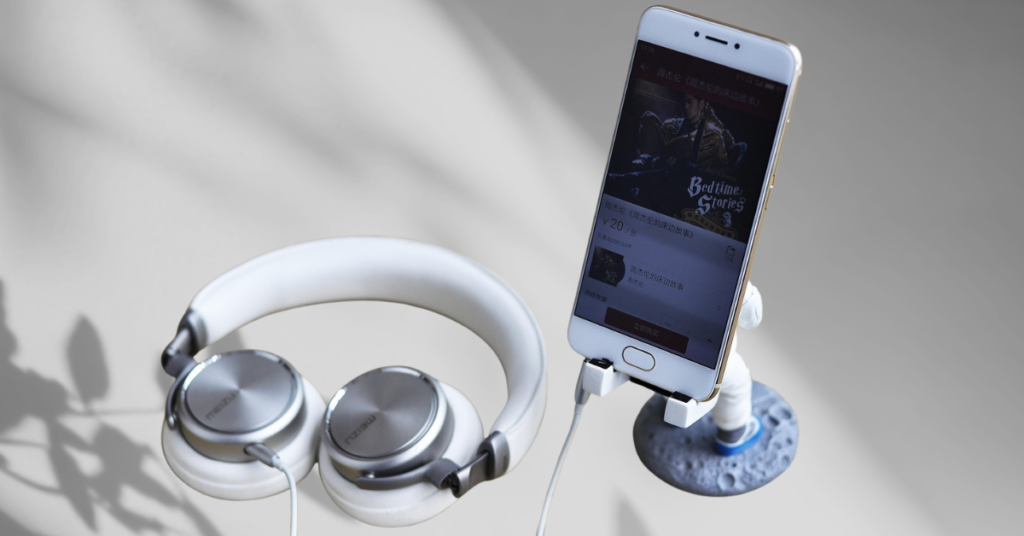 A close-up of a magnetic phone holder mounted inside a car, with a smartphone securely attached. A second magnetic mount sits on a clean desk surface, representing the importance of tech accessories.